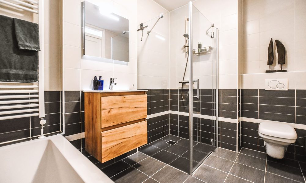 Baño reformado con mueble de madera y ducha