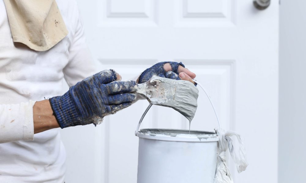 Pintando el interior de una vivienda con brocha y pintura blanca